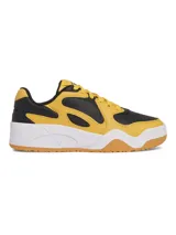 Championes Under Armour modelo Court Anatomix, con diseño bicolor en amarillo y negro. Presentan una parte superior con superposiciones resistentes, entresuela de EVA acolchada y suela exterior de goma gruesa para mayor tracción.