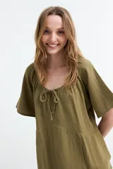 Vestido corto fluido de gasa de algodón color verde militar, con mangas cortas, escote redondo con cordón ajustable en el centro y costura fruncida en la cintura.