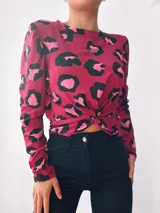 Remera de manga larga color borra de vino con estampado animal print en negro, rosa y lila. Tiene un nudo en la parte delantera.