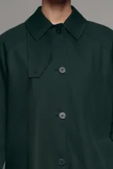 Trench midi ZW Collection verde oscuro con cuello solapa, manga larga, bolsillos laterales en costura y cierre frontal con botones. Cuenta con forro interior a contraste y detalle de solapa corta en el pecho.