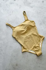 Traje de baño enterizo color dorado con textura brillante, escote recto, tiras anchas y espalda cuadrada.