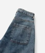 Bermuda baggy de jean color negro con pespuntes contrastantes, cierre de botón y cremallera, y bolsillos.