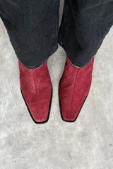 Botas de cuero con textura símil cocodrilo, color bordó, de caña media, punta afilada y taco ancho en color negro.