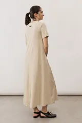 Vestido midi negro con diseño de manga corta, cuello redondo y bolsillos laterales, corte amplio y fluido.