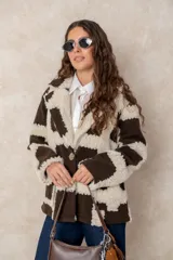 Chaqueta oversize con diseño de cuadros en relieve, confeccionada en una combinación de lana y poliéster con textura tipo borreguillo. Presenta un corte holgado, cuello con solapas y un botón joya central.