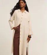 Vestido chemise midi recto color beige, confeccionado en viscolino con cuello camisero, botonadura frontal completa con botones a contratono y mangas 7/8.