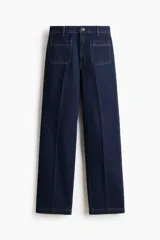 Jean de denim azul oscuro con tiro alto y piernas amplias de corte holgado. Cuenta con bolsillos delanteros de parche, cierre frontal con botón y raya marcada tanto en el frente como en la parte posterior.