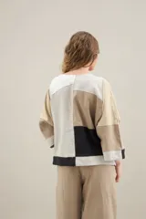 Blusa de diseño patchwork en tonos beige, blanco y tostado, confeccionada con recortes de lino y algodón, cuello redondo, mangas cortas y calce relajado.