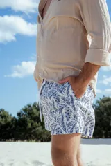 Camisa de manga larga color beige con estampado floral celeste en short.