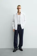 Camisa de corte slim fit confeccionada en tejido de algodón, con cuello italiano, manga larga con puños abotonados y cierre frontal de botones.