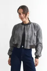 Campera bomber gris de cuero sintético con cuello, puños y ruedo acanalados.