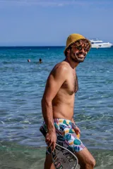 Short de baño con estampado tropical de hojas y elementos lineales sobre fondo blanco. Cuenta con cintura elástica, dos bolsillos laterales, un bolsillo trasero con etiqueta de la marca Von Braun y red interior.