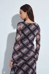 Top de manga larga confeccionado en tejido de malla semitransparente con estampado de cuadros escoceses en tonos marrones, negros y blancos. Presenta un diseño entallado con cuello redondo y terminaciones con efecto ondulado en los puños.