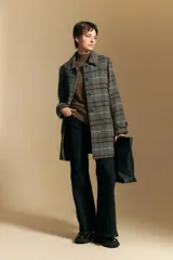 Polera de cuello alto confeccionada en tejido de punto negro, con diseño de textura acanalada en cuello, puños y ruedo, y trama vertical en mangas y espalda.