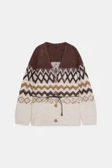 Chaqueta de punto con escote en pico y manga larga, confeccionada en tejido jacquard con diseño geométrico. Presenta detalles de lentejuelas y abalorios, cierre frontal con botones y un cinturón fino ajustable en la cintura.