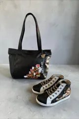 Botas de caña alta de cuero color negro jaspeado y peltre, con diseño de arte pintado a mano en la parte trasera, puntera negra y cordones en tono tostado.