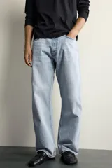 Jeans de denim de algodón en color azul con efecto desgastado, tiro medio y corte recto de ajuste holgado (loose fit). Cuenta con diseño clásico de cinco bolsillos y cierre frontal con cremallera y botón.