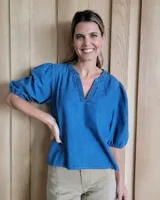 Blusa celeste de denim con cuello en V y mangas abullonadas con puños elásticos.