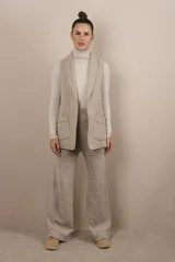 Chaleco color crema con solapas, corte entallado y bolsillos plaqué.