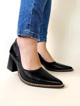 Zapatos de tacón cuadrado color negro, confeccionados en cuero, con punta fina y costuras decorativas visibles en el borde de la suela.