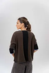 Buzo de punto confeccionado en lambswool, con diseño amplio, escote en V y mangas 3/4. Presenta una combinación de tonos rojos en la espalda con una franja central ancha y tajos laterales.
