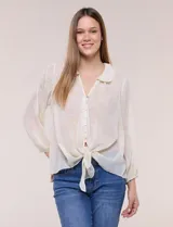 Blusa confeccionada en gasa semitransparente con sutil acabado plisado y estampado floral en tonos suaves. Presenta cuello solapa redondeado, escote en V y botonadura frontal. Mangas largas con puños elásticos y ruedo anudado en la parte inferior frontal.