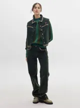 Pantalón de pana verde oscuro, de corte holgado y tiro medio, con detalle de línea lateral color crema.