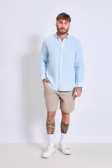 Camisa de corte regular con diseño de rayas verticales finas en tonos claros, cuello clásico y mangas largas con puños abotonados.