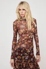 Blusa de tul manga larga con cuello redondo y estampado de mariposas en tonos naranjas y negros, de tejido translúcido y ajustado.