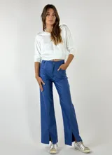 Pantalón azul de corte recto con aberturas en el ruedo.