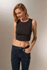 Top cropped negro de poliamida, con cuello a la base y diseño ajustado al cuerpo.