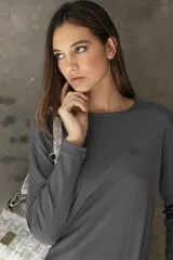 Remera de manga larga en color blanco, con cuello redondo y corte recto de silueta relajada, confeccionada en tejido liviano y suave.