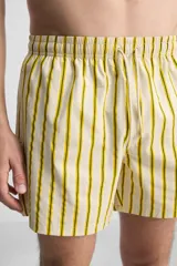 Short de baño confeccionado en tejido técnico, con diseño de rayas verticales amarillas y verdes sobre fondo blanco. Cuenta con cintura elástica ajustable con cordón, bolsillos laterales y bolsillo trasero con vivo.