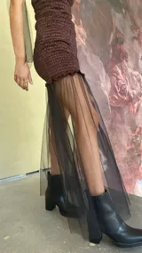 Vestido strapless de satén color marrón con cuerpo elástico tipo nido de abeja y falda de tul transparente superpuesta. Incluye un cuello desmontable de tul a juego.