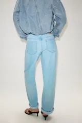 Pantalón de jeans estilo relaxed fit, de tiro alto, color azul con efecto lavado y botamanga con vuelta. Cuenta con cinco bolsillos, trabillas para cinto y cierre frontal con cremallera y botón metálico.