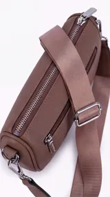 Bandolera de cuero sintético negro con diseño estructurado, múltiples bolsillos con cierre, correa ancha ajustable y herrajes metálicos plateados.