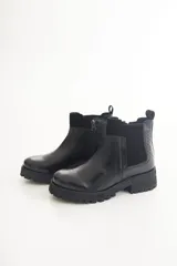 Botas Chelsea negras de cuero con elástico lateral, suela track y tirador trasero.