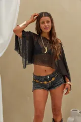 Poncho corto de lurex negro transparente, con diseño asimétrico y mangas amplias tipo capa.
