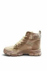 Bota borcego color beige con cordones, suela gruesa track y tira con hebilla decorativa en la zona del tobillo.