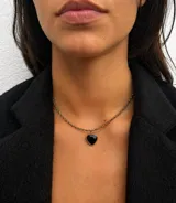 Gargantilla delicada compuesta por pequeñas piedras semipreciosas facetadas en tonos oscuros y dorados, con un dije central en forma de corazón de piedra natural negra enmarcado en metal.