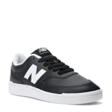 Championes urbanos New Balance modelo 080, color negro con detalles en blanco. Presentan un diseño de corte bajo con capellada de cuero sintético, perforaciones en la puntera para mayor ventilación, el logo 'N' característico en los laterales y suela de goma blanca.