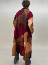 Tapado oversize desestructurado de lana merino afieltrada, ensamblada y teñida en degradé. Con bolsillos laterales, puños amplios y cierre con broches ocultos. Más largo en la parte inferior trasera.