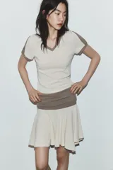 Falda mini de tiro bajo con cintura elástica ancha en color marrón y falda en color beige con bajo asimétrico.