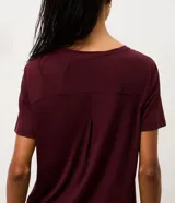 Remera deportiva de manga corta con cuello redondo, confeccionada en poliamida y elastano. Presenta un diseño liso con detalle de recorte en la espalda.