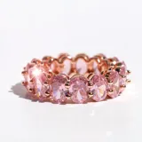 Anillo de acero con acabado en oro rosa, con cristales ovalados rosas engarzados en todo el contorno.