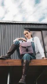 Mochila de diseño compacto con tapa frontal y cierre de hebilla tipo clip. Cuenta con correas ajustables, asa superior, bolsillos laterales y bolsillo trasero con cierre.