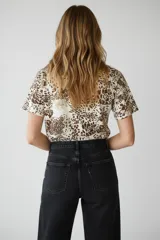 Remera de manga corta con cuello a la base y diseño holgado, confeccionada en algodón con elastano y estampado animal print.