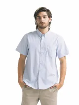 Camisa de hombre de manga corta con estampado a cuadros en tonos blanco, verde y marrón. Tiene cuello abotonado y bolsillo en el pecho.
