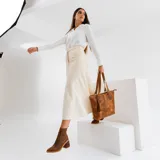 Botas tipo chelsea de cuero vacuno negro, con elásticos laterales, taco cuadrado y punta fina.