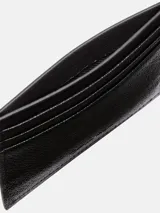 Tarjetero plano de piel granulada negra con seis ranuras para tarjetas y una ranura central. Presenta protección RFID y el logo de Calvin Klein grabado en la parte delantera.